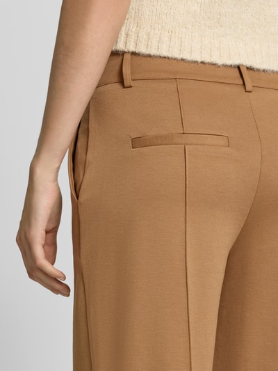 Frauenmodel trägt Wide Fit Hose mit Viskose-Anteil Modell 'Kate' von ICHI in Beige mit Ziernähten, Gesäßtaschen, Detailaufnahme.