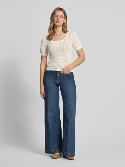 Frauenmodel trägt Slim Fit T-Shirt aus reiner Baumwolle Modell 'SCOUT' von Pieces in Optik: Unifarben mit Struktur, semitransparente-Optik, U-Ausschnitt, Kurzarm, Ärmelabschluss: Gerippt, Rumpfabschluss: Gerippt, Materialverarbeitung: Strick, Ganzkörperansicht von vorne.