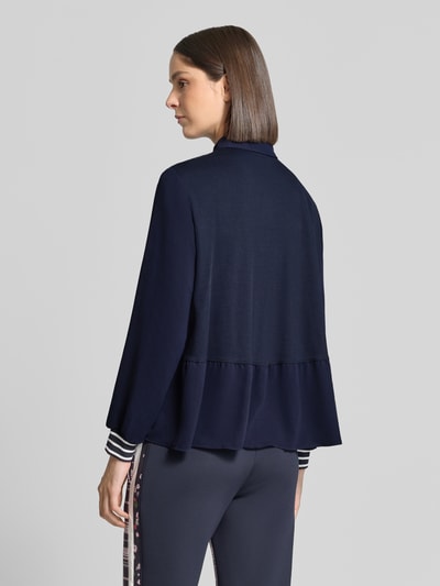 Kobieta nosi Regular Fit koszulkę polo z elastycznymi zakończeniami rękawów od Marc Cain, kołnierzyk polo, z długim rękawem, długość tyłu w rozmiarze 36: 63 cm, widok całej sylwetki z tyłu.