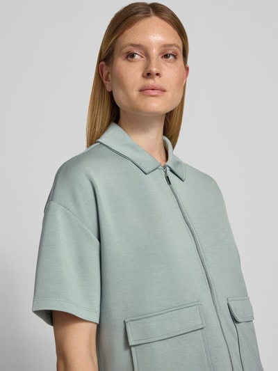 Frauenmodel trägt Jacke mit Umlegekragen von Christian Berg Woman, Elastischer-Material-Mix, Gerader-Schnitt, Reißverschluss, 1/2-Arm, AufgesetzteTaschen, hellgrün, glatte Struktur, Nahaufnahme Oberkörper.