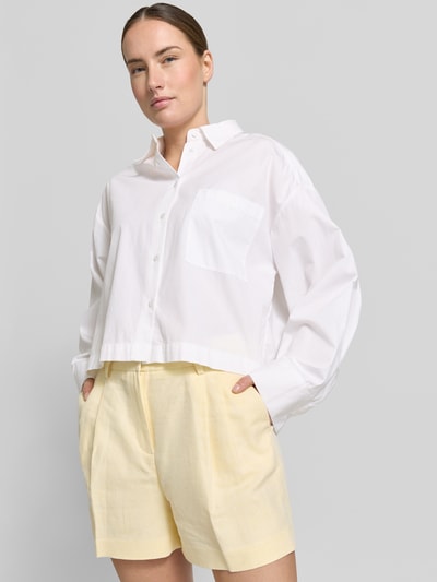 Vrouwenmodel draagt Shorts met steekzakken en strookzak aan de achterkant van MICHAEL Michael Kors, mix van katoen en linnen, loose fit, haakjes- en ritssluiting, Franse steekzakken, bandwijdte maat 36: 38 cm, binnenbeenlengte maat 36: 10 cm, voorkant bovenlichaam close-up.