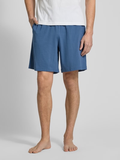 Männermodel trägt Regular Fit Sweatshorts aus Baumwoll-Mix von Tommy Hilfiger in Blau, unifarben, elastischer Bund, Nahaufnahme Oberschenkel.