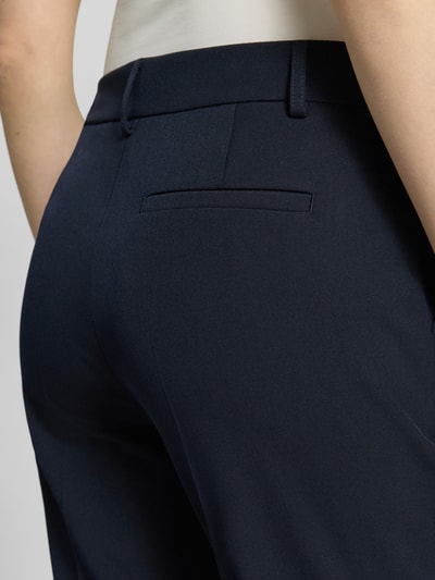 Frauenmodel trägt Hose in verkürzter Passform mit Längsnähten von Christian Berg Woman Selection, dunkelblau, Detailaufnahme Rückansicht. Material-Mix mit Viskose, Gesäßtasche, glatte Textur.