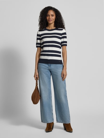 Frauenmodel trägt Strickshirt mit Rundhalsausschnitt und Label-Detail von More & More, gestreift, Viskose-Elasthan-Mix, Regular-Fit, Ganzkörperansicht von vorne. Rückenlänge bei Größe 36: 56 cm, Ärmellänge bei Größe 36: 25 cm.