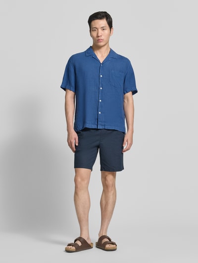 Męski model nosi Regular Fit Leinenhemd mit Brusttasche und Label-Stitching od Gant, lniany materiał, niebieski, krój regular fit, kieszeń na piersi, naszywka z logo, długość tyłu w rozmiarze M: 69 cm, szerokość w rozmiarze M: 48 cm, długość rękawa w rozmiarze M: 24 cm, całkowity widok z przodu