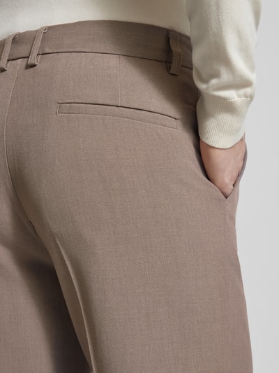 Męski model nosi Slim Fit Stoffhose mit Viskose-Anteil od Lindbergh, elastyczna mieszanka materiałów, kanty, wpuszczane kieszenie, detal z tyłu, zapięcie na haftkę i zamek błyskawiczny; szerokość w rozmiarze M: 37 cm, długość wewnętrzna nogawki w rozmiarze M: 80 cm; zbliżenie na tył.