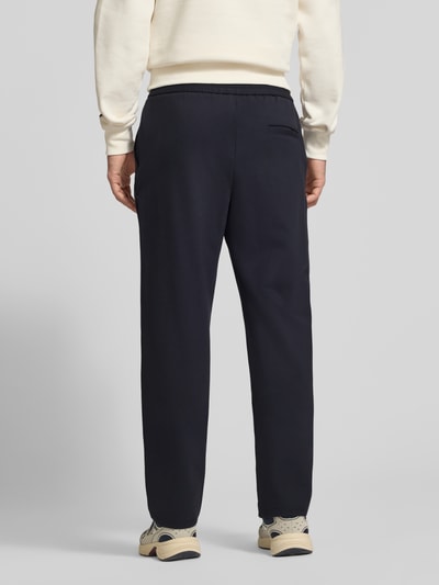Mannenmodel draagt donkerblauwe broek met rechte pijpen van Viscosemix, elastische band, Model 'Karl' van JACK & JONES, binnenbeenlengte maat M 79 cm, bandwijdte 41 cm, volledige achteraanzicht.