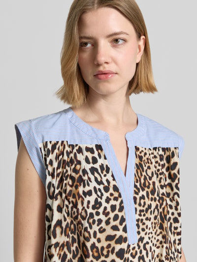 Frauenmodel trägt Relaxed Fit Bluse aus reiner Viskose mit Allover-Animal-Print von Emily Van den Bergh, Tunika-Ausschnitt, Ärmelloses-Design, beige, braun, schwarz, gemustert, Nahaufnahme Oberkörper. Damen Bluse, Rückenlänge bei Größe 36: 59 cm.