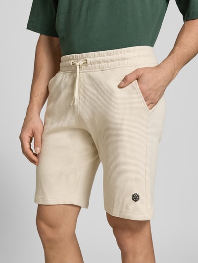 Männermodel trägt Straight Fit Shorts mit Logo-Stitching Modell 'Fillip' von Blend aus Reine Baumwolle mit Strukturmuster, Eingrifftaschen, elastischer Bund mit Tunnelzug, Nahaufnahme Oberkörper.