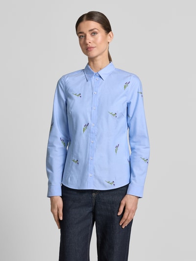 Modelka kobieca nosi Hemdbluse mit Motiv-Stitchings od Christian Berg Woman, czysta bawełna, prosty krój, niebieska, Kent kołnierzyk, zapięcie na guziki, sportowe mankiety, motyw haftowany, długość tyłu w rozmiarze 36: 62 cm, długość rękawa w rozmiarze 36: 62 cm, widok całej sylwetki z przodu.