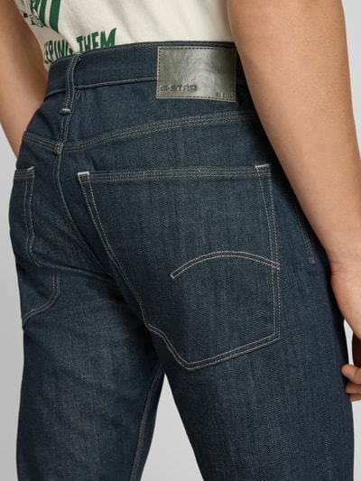 Männermodel trägt Slim Tapered Fit Jeans Modell 'Streem' von G-Star Raw in Dunkelblau, reine Baumwolle, Detailaufnahme Rückansicht.