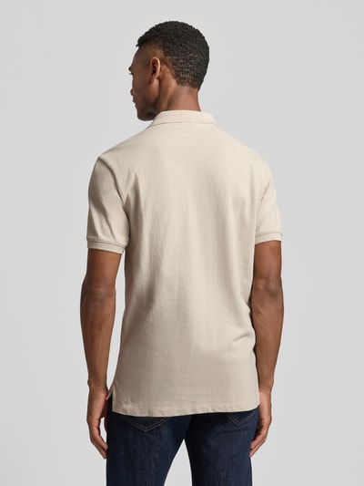 Männermodel trägt Slim Fit Poloshirt mit Label-Stitching von GAP in Beige, Baumwoll-Elasthan-Mix, Rückenlänge 70 cm, Ganzkörperansicht Rückansicht.