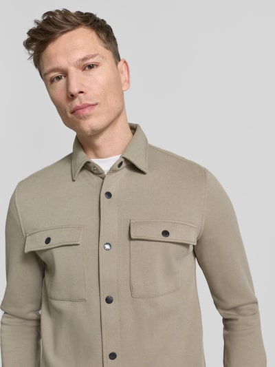 Mannelijk model draagt Hemdjacke met drukknoopsluiting van MCNEAL in regular fit, zandkleur, borstzakken, kentkraag, bovenlichaam close-up.
