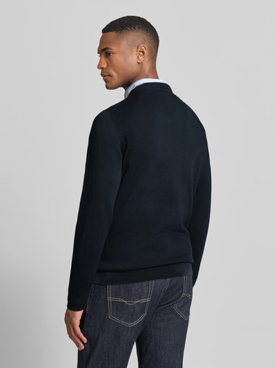 Männermodel trägt Regular Fit Strickpullover aus reiner Baumwolle Modell 'PIMA' von Barbour, unifarben, Stricktextur, Ganzkörperansicht Rückansicht.