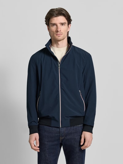 Männermodel trägt Jacke mit Stehkragen von Christian Berg Men in Dunkelblau, Material-Mix mit Stretch-Anteil, Reißverschlusstaschen, Lockerer-Schnitt, gerippte-Abschlüsse, Ganzkörperansicht von vorne.