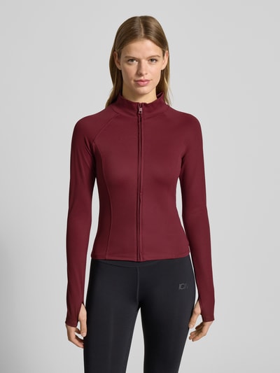 Vrouwenmodel draagt Slim Fit Sweatjacke met Stehkragen Modell 'Yoga' van Gina Tricot, bordeaux, elastische stof, voorkant, bovenlichaam close-up.