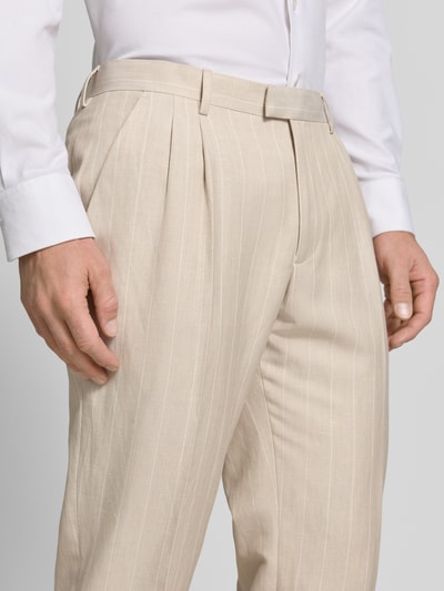 Männermodel trägt Anzughose mit Bügelfalten und Eingrifftaschen von MCNEAL in Beige mit feinem Streifenmuster, Nahaufnahme Oberkörper, Straight Fit, Haken-, Knopf- und Reißverschluss, französische Eingrifftaschen, Gesäßleistentaschen, Bundweite bei Größe 50: 37 cm, Innenbeinlänge bei Größe 50: 75 cm.