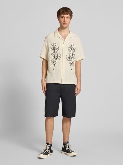 Männermodel trägt Relaxed Fit Freizeithemd aus reiner Baumwolle Modell 'JACKSON' von Only & Sons, cremefarben mit Stickerei, Seersucker-Struktur, Kurzarm, Ganzkörperansicht von vorne