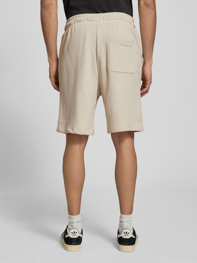 Männermodel trägt Sweatshorts mit Logo Modell 'KANE' von Jack & Jones, Beige, Baumwoll-Mix, Relaxed-Fit, Ganzkörperansicht Rückansicht.
