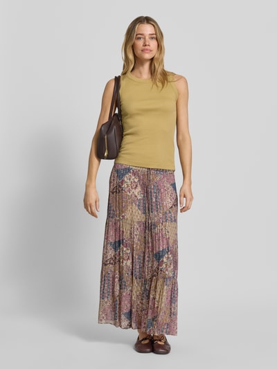 Frauenmodel trägt Maxirock aus Viskose mit Kordelzug Modell 'PITSY' von Bash, A-Linie, Volantsaum, florale Muster, Ganzkörperansicht von vorne.