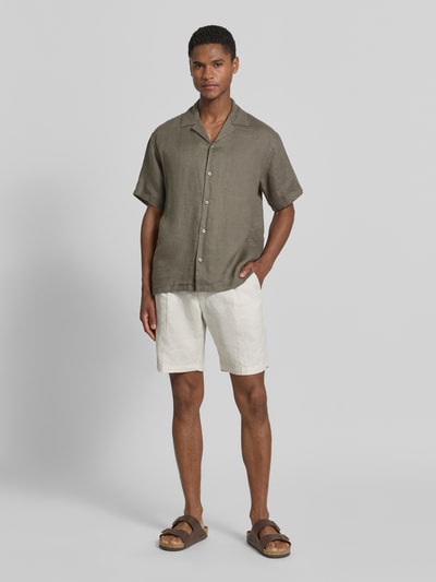 Männermodel trägt Regular Fit Leinenhemd Modell 'LAWRENCE' von Jack & Jones Premium in Oliv mit Reverskragen, Ganzkörperansicht von vorne.