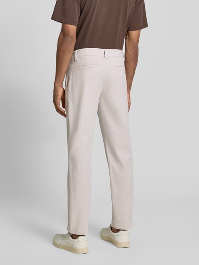 Männermodel trägt Tapered Fit Chino aus Baumwoll-Mix Modell 'CHINO PLEATED' von BOSS Orange, Optik: Unifarben, Materialverarbeitung: Twill, Ganzkörperansicht Rückansicht.