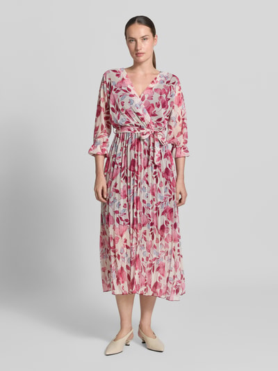 Frauenmodel trägt Midikleid im Allover-Look mit Bindegürtel von ZABAIONE in A-Linie, V-Ausschnitt, florale Muster, Ganzkörperansicht von vorne.