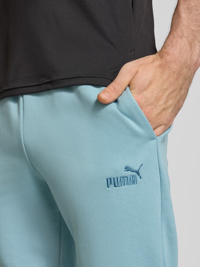 Männermodel trägt Sweatpants mit elastischem Bund von PUMA PERFORMANCE aus Baumwoll-Mix, Label-Stitching, Eingrifftaschen, Nahaufnahme Oberkörper.