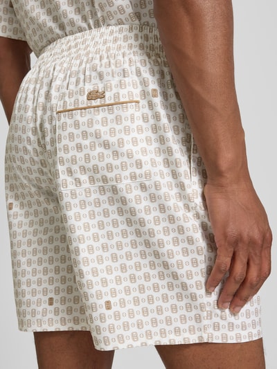 Mężczyznamodel nosi Regular Fit Chinoshorts aus Baumwoll-Viskose-Mix model 'Aop Short Tenniscourt' von Lacoste, jasny krem z beżowym wzorem, tekstura gładka, Herren Chinoshorts von Lacoste, detal tylnej części, zbliżenie na biodra