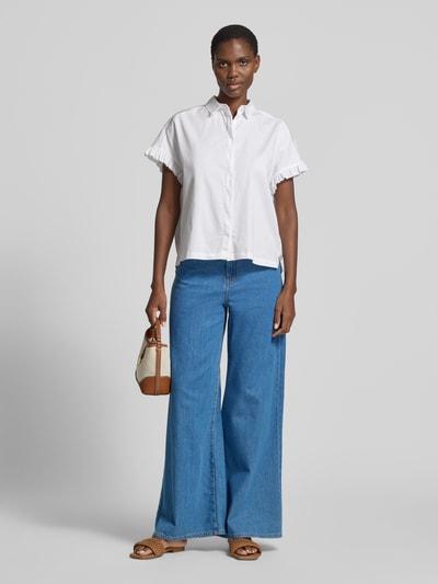 Frauenmodel trägt Regular Fit Bluse mit verdeckter Knopfleiste von Smith and Soul aus weißem Baumwoll-Mix mit Stretch-Anteil, kurzen Ärmeln mit Rüschen, Hemdblusenkragen und lockerer Passform, kombiniert mit weiter Jeans, Ganzkörperansicht von vorne.