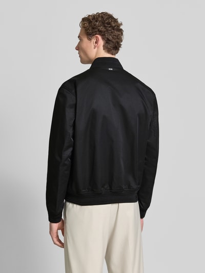 Männermodel trägt Regular Fit Blouson von BOSS, Optik: Unifarben, Passform: Regular-Fit, Verschluss: Reißberschluss, seitliche Eingrifftaschen, Ganzkörperansicht Rückansicht.