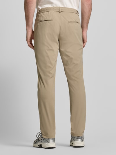 Männermodel trägt beige Sweatpants mit elastischem Bund von Guess, gerader Schnitt, Gesäßtaschen, Ganzkörperansicht Rückansicht.