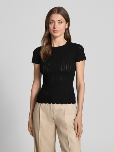 Frauenmodel trägt Slim Fit Strickpullover aus Viskose-Mix Modell 'FICE' von BOSS Orange in Schwarz, Struktur-Muster, Kurzarm, Rundhals, Strickoptik, Label-Applikation, Ganzkörperansicht von vorne.