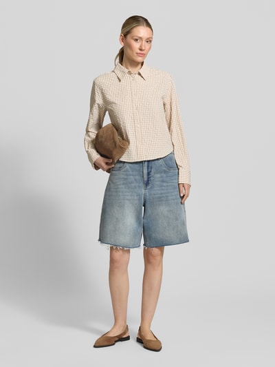Frauenmodel trägt Wide Leg Jeansshorts im 5-Pocket-Design von Gestuz in hellem Blau, dezente Waschung, kombiniert mit beigefarbenem Hemd, Ganzkörperansicht von vorne, elastischer Baumwoll-Mix.