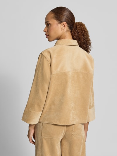 Frauenmodel trägt Loose Fit Hemdbluse mit Pattentaschen Modell 'Ferrell' von OPUS in Beige mit weicher Textur, Ganzkörperansicht Rückansicht.