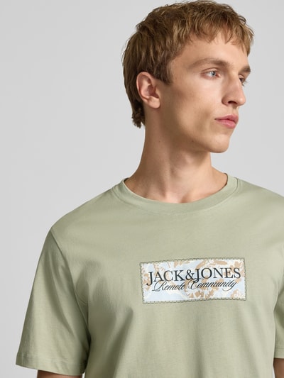 Männermodel trägt T-Shirt mit Label-Print von Jack & Jones in hellem Grün, Reine Baumwolle, Gerader-Schnitt, Rundhalsausschnitt, Nahaufnahme Oberkörper.