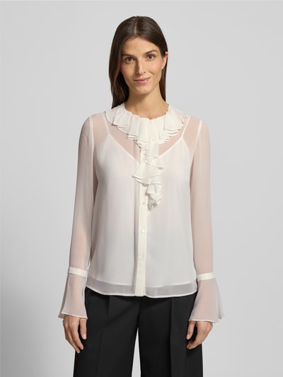 Modelka kobieca nosi Regular Fit Langarmbluse mit Top aus reiner Seide od Max Mara Studio, biała, półprzezroczysta, z falbanami, widok całej sylwetki z przodu.