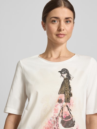 Modelka nosi T-Shirt mit Motiv-Print und Pailletten od Oui, czysta bawełna, krój regular fit, okrągły dekolt, biel z kolorowym nadrukiem i cekinami, widoczny nadruk z motywem, kontekst damska koszulka, długość tyłu w rozmiarze 36: 58 cm, zbliżenie na górną część ciała