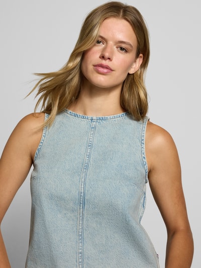 Frauenmodel trägt Regular Fit Blusentop aus reiner Baumwolle Modell 'DENIM SHELL' von Levi's®, hellblau, strukturierter Stoff, Nahaufnahme Oberkörper, Damen Blusentop von Levi's®.