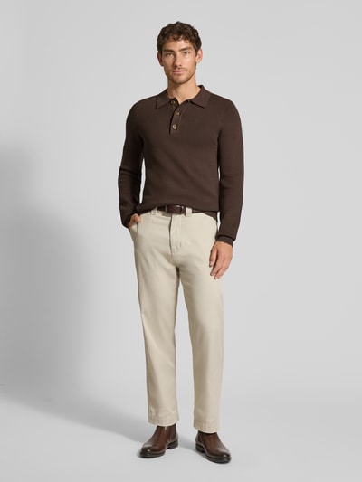 Männermodel trägt Strickpullover mit Polokragen Modell 'ABEL' von Casual Friday, dunkelbraun, glatte Textur, Regular Fit, Ganzkörperansicht von vorne. Baumwoll-Mix mit Viskose-Anteil, Knopfleiste, Rücklänge 72 cm, Ärmellänge 73 cm.