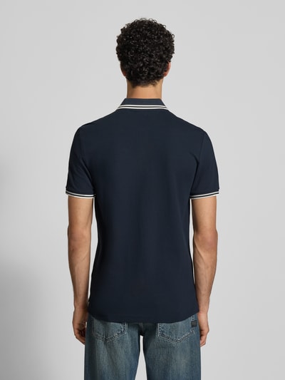 Männermodel trägt Slim Fit Poloshirt mit Logo-Stitching Modell 'Dunda' von G-Star Raw aus elastischem Baumwoll-Mix, Dunkelblau, Polokragen, Rückenlänge bei Größe M 72 cm, Ganzkörperansicht Rückansicht.