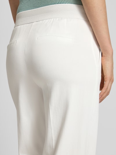 Kobiece modelka nosi Hose mit Bügelfalten und Gesäßtaschen od Betty Barclay, bawełniany miks z dodatkiem wiskozy, wide leg, kieszenie z tyłu, szerokość w rozmiarze 36: 39 cm, długość nogawki wewnętrznej 78 cm, ujęcie z tyłu, zbliżenie na dolną część pleców.