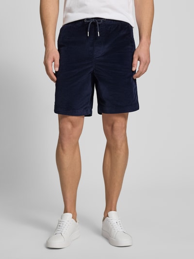 Männermodel trägt Regular Fit Sweatshorts aus Baumwoll-Mix von SELECTED HOMME, efekt: jednolity kolor, krój regular fit, tunel, ściągacz, kieszeń z tyłu, wpuszczane kieszenie, wykończenie materiału: sztruks, mieszanka bawełny, Ganzkörperansicht von vorne