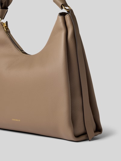 Produktfoto, Handtasche mit Logo-Print Modell 'Grana' von Coccinelle in Beige, strukturierte Leder-Optik, goldfarbene Details, Flecht-Trageriemen
