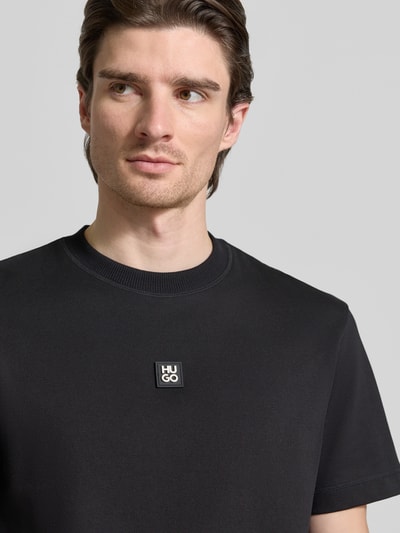 Männermodel trägt Regular Fit T-Shirt mit Baumwoll-Anteil Modell 'DILANSO' von HUGO, unifarben, Rundhals, Nahaufnahme Oberkörper.