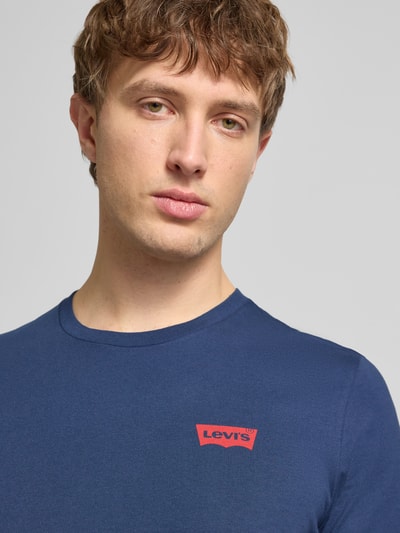 Männermodel trägt T-Shirt mit Label-Print im 2er-Pack von Levi's®, reine Baumwolle, Slim-Fit, gerippter Rundhalsausschnitt, Nahaufnahme Oberkörper.