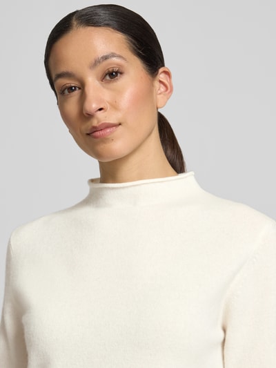 Vrouwenmodel draagt gebreid shirt uit zuiver wol model 'Tumea' van Someday in regular fit met opstaande kraag en rolzoom, nahaufnahme bovenlichaam. Ruglengte bij maat 36: 52 cm, mouwlengte bij maat 36: 34 cm.