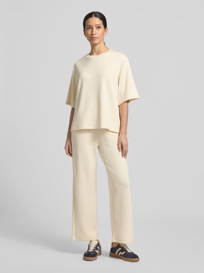 Modelka nosi T-Shirt mit Rundhalsausschnitt od Soyaconcept, kolor kremowy, luźny krój relaxed fit, modal, materiał gładki, widok od przodu, całe ciało.