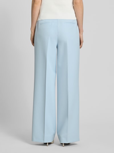 Frauenmodel trägt Stoffhose mit Leistentaschen und Bügelfalte von More & More aus Material-Mix mit Stretch-Anteil in Hellblau, Ganzkörperansicht Rückansicht.