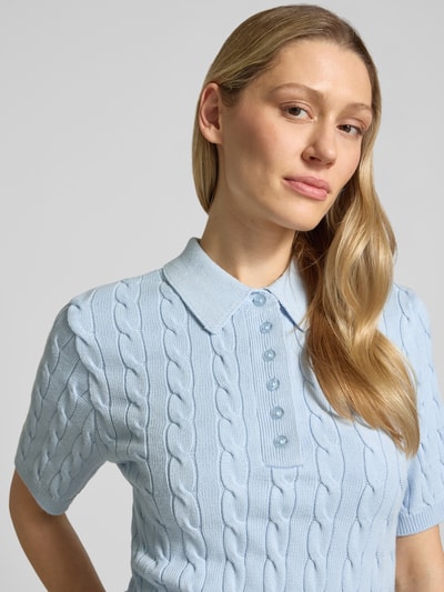 Frauenmodel trägt Slim Fit Poloshirt aus Viskose-Mix Modell 'Thilla' von Gestuz, Strick-Optik, hellblau, Halbarm, Nahaufnahme Oberkörper. Damen Poloshirt Kontext: Polokragen, elastische Abschlüsse, Rückenlänge 51 cm, Ärmellänge 25 cm.